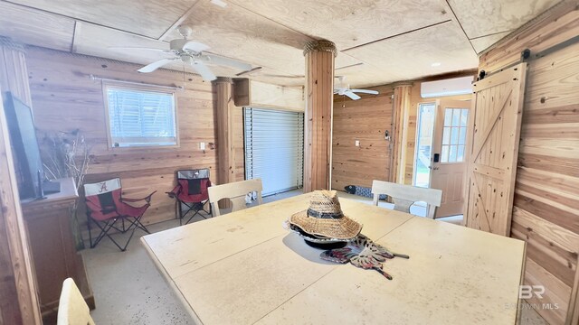 dining space featuring a barn door, a healthy amount of sunlight, and ceiling fan