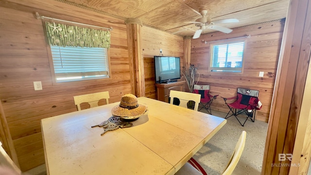 dining room with wooden walls and ceiling fan