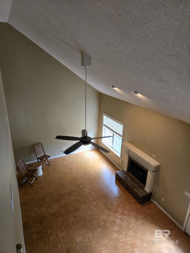 unfurnished living room featuring a ceiling fan, a fireplace, baseboards, and a textured ceiling