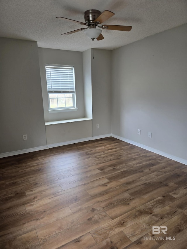 empty room featuring a ceiling fan, a textured ceiling, baseboards, and wood finished floors