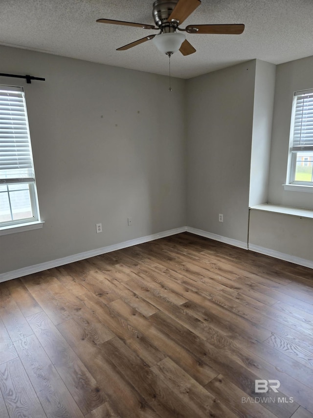 unfurnished room featuring a ceiling fan, a textured ceiling, baseboards, and wood finished floors