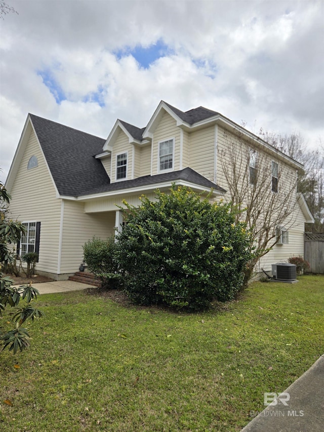 view of home's exterior featuring a yard, central AC unit, and a shingled roof