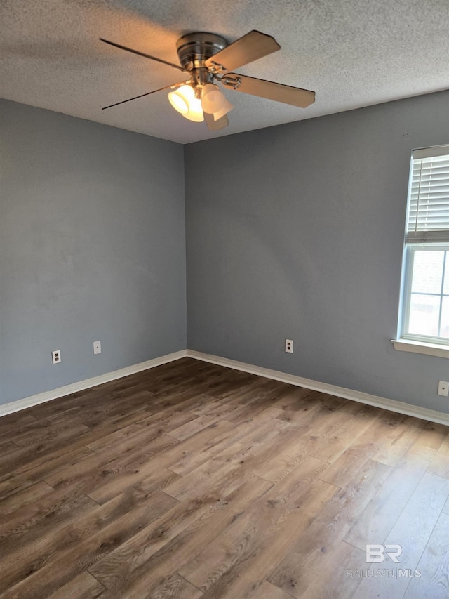 unfurnished room featuring ceiling fan, a textured ceiling, baseboards, and wood finished floors