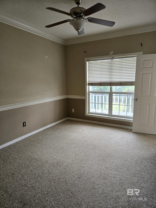 carpeted spare room featuring a textured ceiling, ceiling fan, ornamental molding, and baseboards