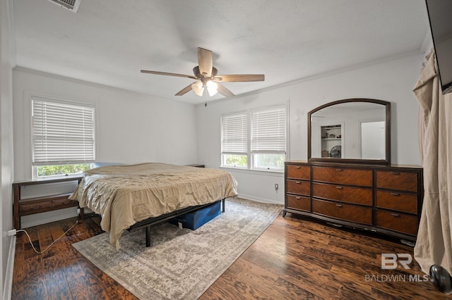 bedroom featuring multiple windows, ornamental molding, dark wood finished floors, ceiling fan, and baseboards