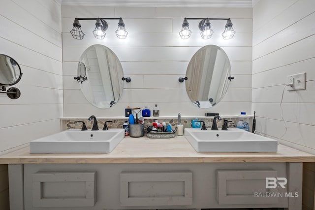 full bath featuring double vanity, crown molding, and wooden walls