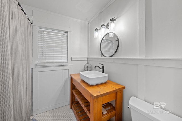bathroom with crown molding, toilet, vanity, and curtained shower