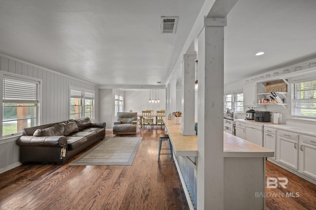 living area with dark wood finished floors, ornamental molding, baseboards, and recessed lighting