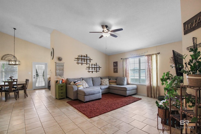 living room with lofted ceiling, light tile patterned floors, and ceiling fan