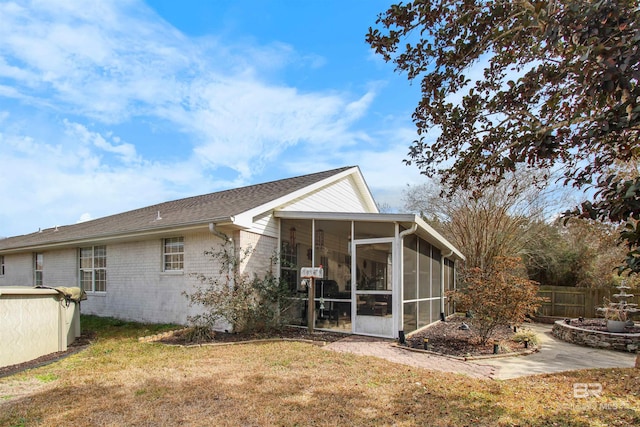 rear view of house with a sunroom and a yard