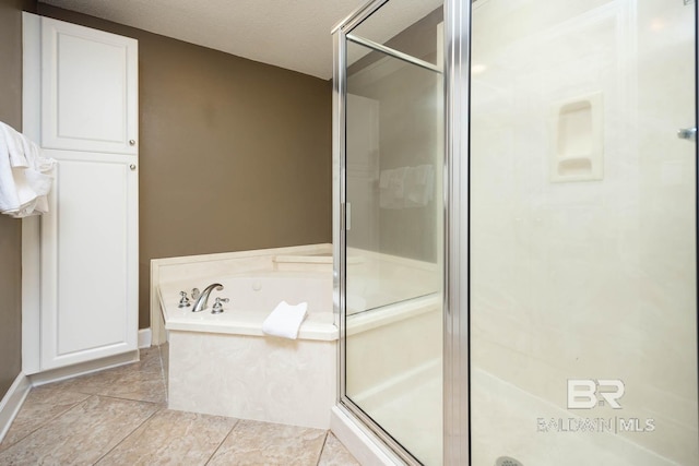 bathroom with tile patterned flooring, separate shower and tub, and a textured ceiling