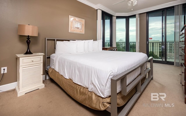 carpeted bedroom featuring access to outside, ceiling fan, crown molding, and a wall of windows