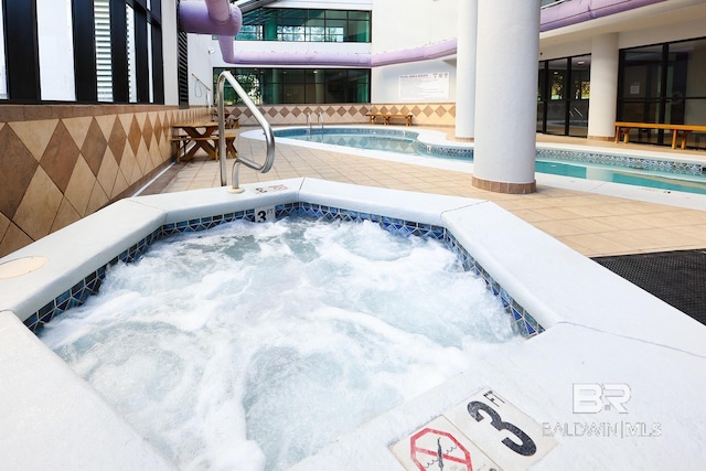 view of swimming pool featuring a hot tub