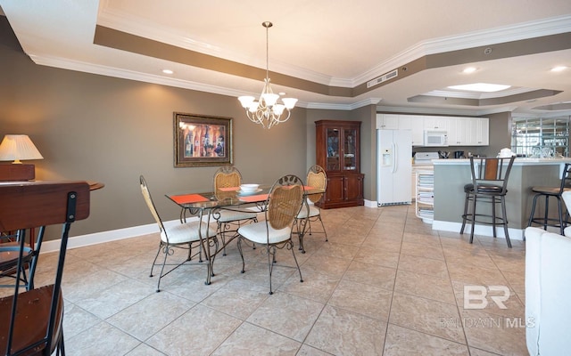 dining area with light tile patterned floors, a tray ceiling, ornamental molding, and a notable chandelier