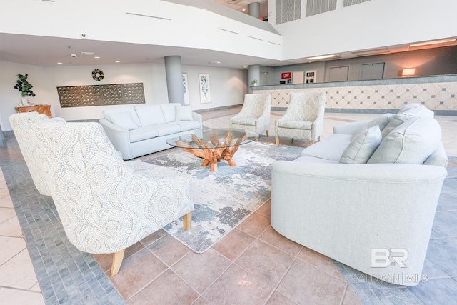 living room with light tile patterned floors and a high ceiling