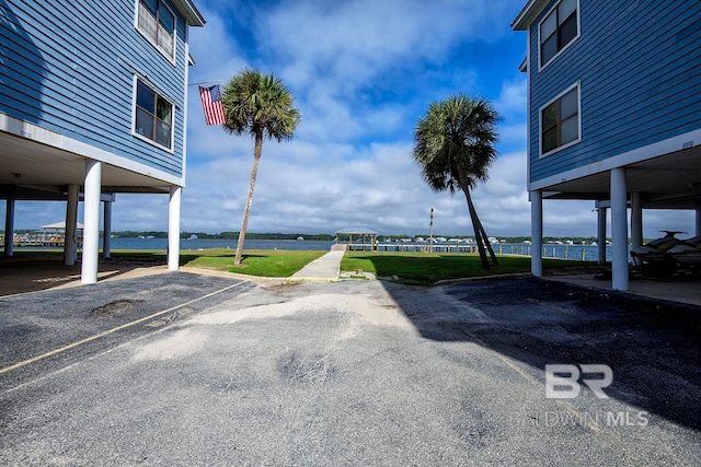 view of parking with a carport and a lawn