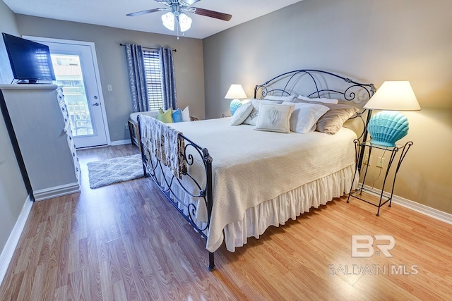 bedroom featuring light hardwood / wood-style flooring, ceiling fan, and access to outside