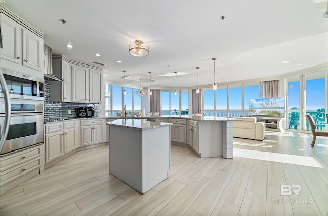 825 W Beach Blvd Unit 10, Gulf Shores, AL 36542 - kitchen featuring a peninsula, a healthy amount of sunlight, decorative backsplash, and a sink