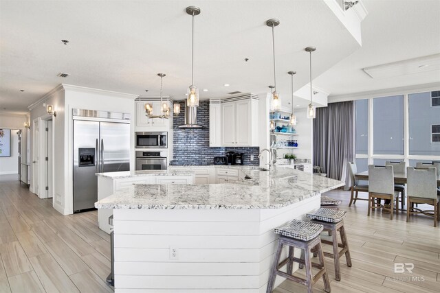 825 W Beach Blvd Unit 10, Gulf Shores, AL 36542 - kitchen with ornamental molding, built in appliances, wood tiled floor, wall chimney range hood, and backsplash