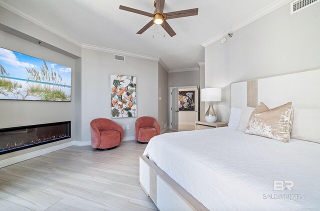 825 W Beach Blvd Unit 10, Gulf Shores, AL 36542 - bedroom featuring a ceiling fan, visible vents, crown molding, and a glass covered fireplace