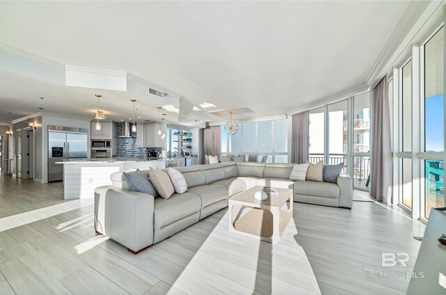 825 W Beach Blvd Unit 10, Gulf Shores, AL 36542 - living area featuring ornamental molding, light wood-style flooring, visible vents, and a notable chandelier