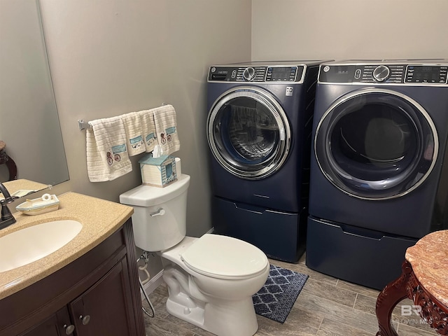 bathroom featuring separate washer and dryer, vanity, toilet, and hardwood / wood-style floors