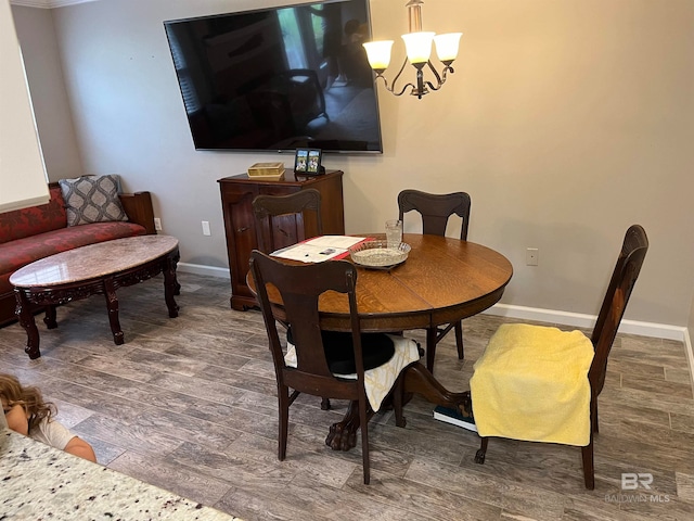 dining space featuring dark wood-type flooring and an inviting chandelier