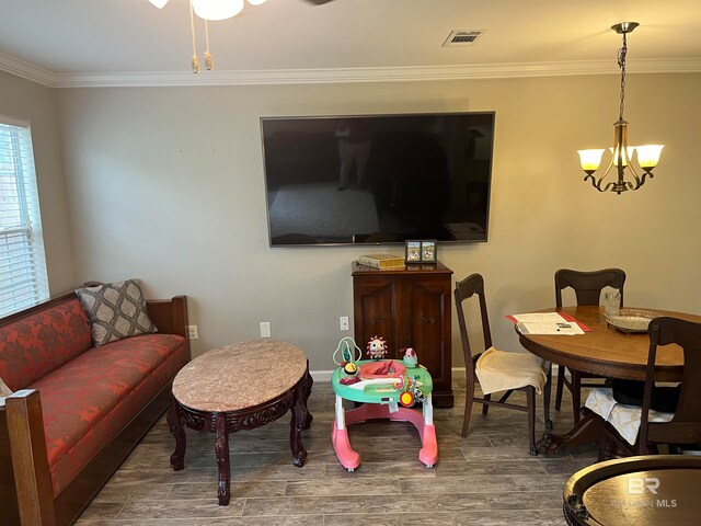 living room featuring crown molding, an inviting chandelier, and dark hardwood / wood-style flooring