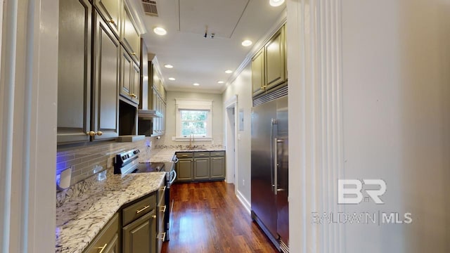 kitchen featuring dark hardwood / wood-style flooring, tasteful backsplash, light stone counters, ornamental molding, and stainless steel appliances