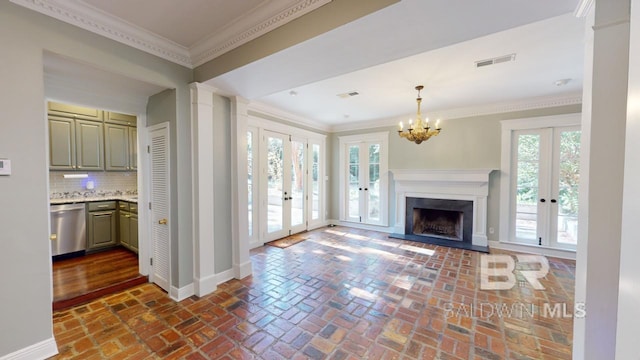 living room featuring french doors, an inviting chandelier, and crown molding