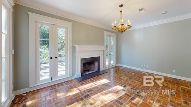 unfurnished living room with crown molding, french doors, and an inviting chandelier