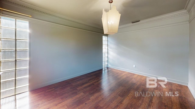 spare room featuring dark hardwood / wood-style flooring and crown molding