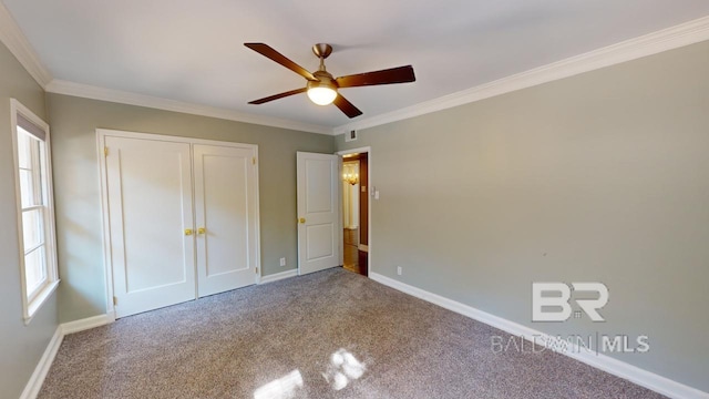 unfurnished bedroom featuring a closet, ceiling fan, crown molding, and carpet