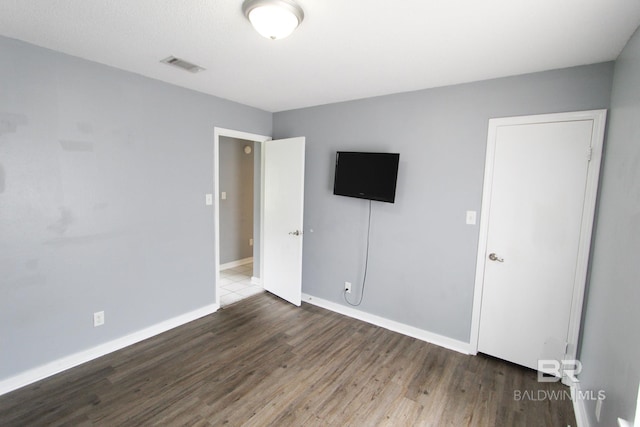 unfurnished bedroom with dark hardwood / wood-style flooring