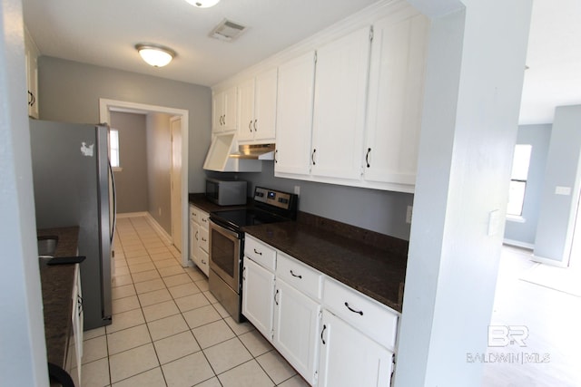 kitchen featuring white cabinets, light tile patterned flooring, stainless steel appliances, and a wealth of natural light