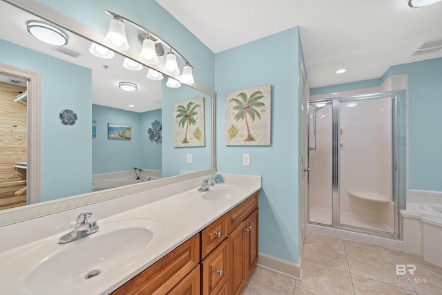 bathroom featuring a shower with door, vanity, a textured ceiling, and tile patterned flooring