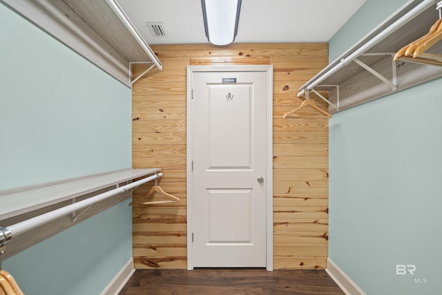 spacious closet featuring dark hardwood / wood-style flooring