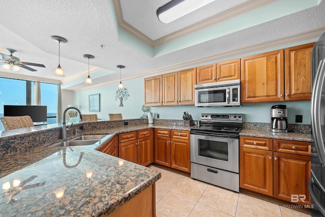 kitchen featuring a raised ceiling, sink, a textured ceiling, and appliances with stainless steel finishes