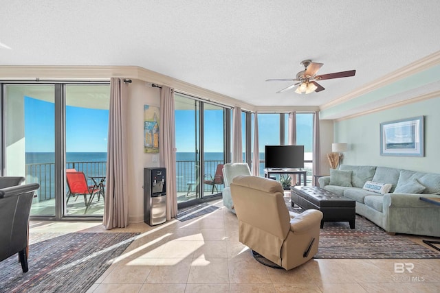 living room featuring ceiling fan, light tile patterned flooring, a textured ceiling, and ornamental molding