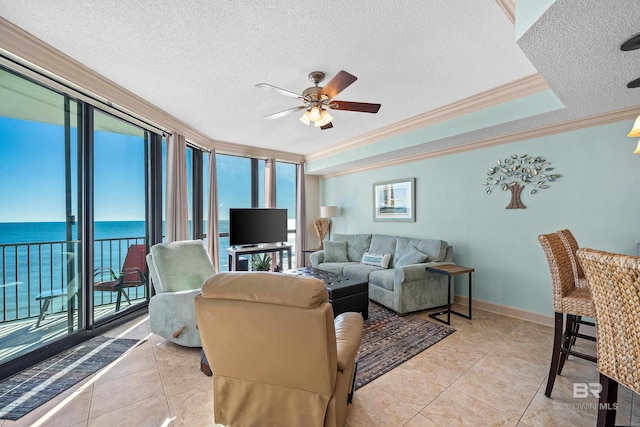 living room with a textured ceiling, a water view, ceiling fan, and ornamental molding