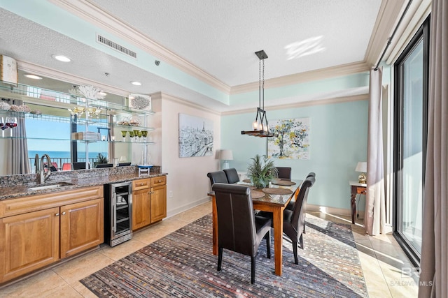 tiled dining area featuring a wealth of natural light, ornamental molding, a textured ceiling, and beverage cooler