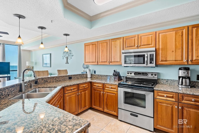 kitchen featuring a textured ceiling, stainless steel appliances, a raised ceiling, sink, and hanging light fixtures