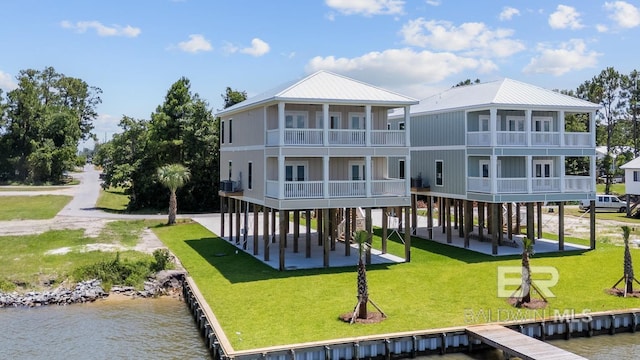 25995 W Perdido Ave, Orange Beach, AL 36561 - rear view of house featuring a water view and a lawn