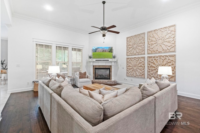 living room with dark hardwood / wood-style floors, ceiling fan, ornamental molding, and a brick fireplace