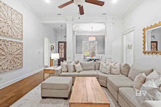 living room featuring ceiling fan with notable chandelier, light hardwood / wood-style floors, and ornamental molding