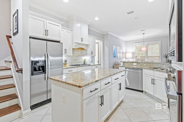 kitchen with a center island, white cabinets, hanging light fixtures, kitchen peninsula, and stainless steel appliances