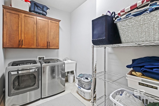 laundry room with light tile patterned floors, cabinets, and independent washer and dryer