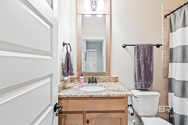 bathroom featuring a shower with curtain, vanity, and toilet