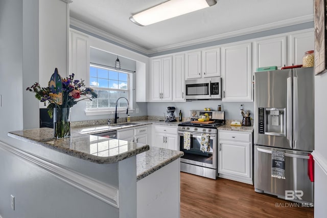9678 Nottingham Ct, Daphne, AL 36526 - kitchen featuring appliances with stainless steel finishes, white cabinets, a peninsula, ornamental molding, and light stone countertops