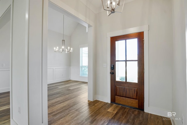 entryway with a decorative wall, wood finished floors, a wainscoted wall, and a chandelier